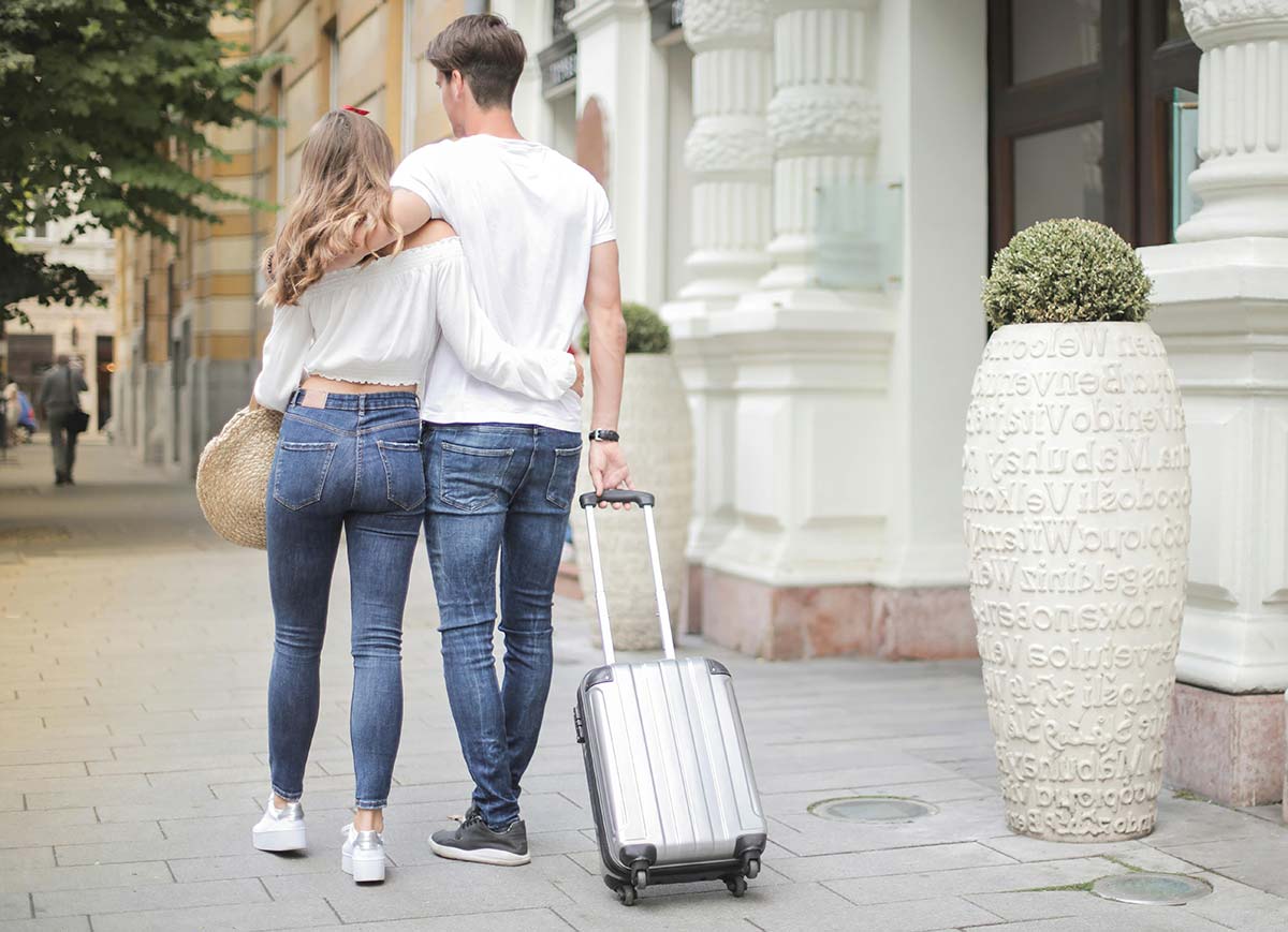Pareja paeando por la ciudad con su maleta