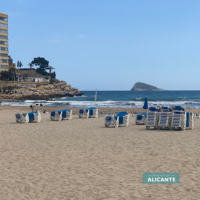 Sombrillas en la Cala de Finestrat con la isla de Benidorm al fondo