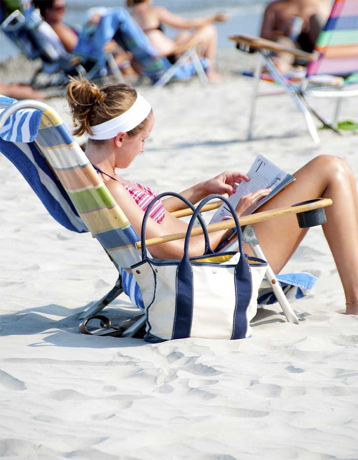 Joven leyendo en la playa del arenal en Alicante